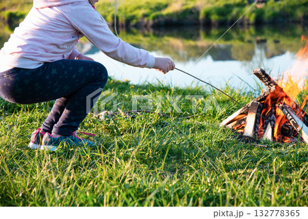 Burning fire on the shore of the reservoir 132778365