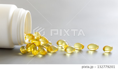 Yellow softgels (gelatin capsules) and bottle on a grey close up. Omega 3 Fish oil or garlic oil 132779201