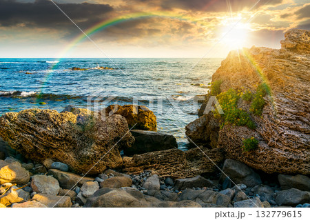 weekend on a rocky beach at the black sea under open blue sky at sunset. beautiful coastline in summer. seascape scenery with clouds above horizon in evening light. sunny weather 132779615