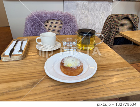 Morning tea and pastry served at a cozy cafe table. Relaxation, warmth and balance in urban lifestyle and simple pleasures. 132779634