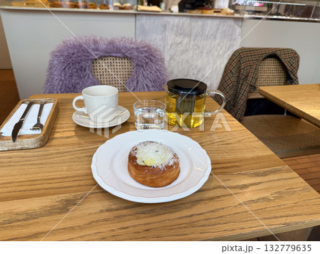 Cafe table with tea and pastry during a cozy morning break. Warmth, comfort and everyday joy in relaxed lifestyle moments. Cafe table with tea and pastry during a cozy morning break. Warmth, comfort and everyday joy in relaxed lifestyle moments. 132779635