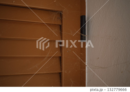 Thick cobwebs covering old window shutters, signaling a serious need for professional cleaning Thick cobwebs covering old window shutters, signaling a serious need for professional cleaning 132779666