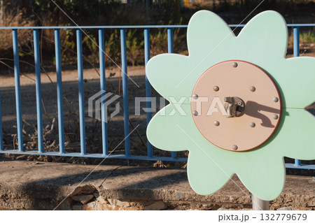 Water fun for kids: a whimsical flower-shaped water tap on a sunny public playground 132779679