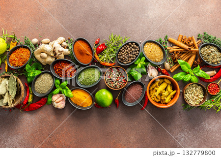 A stunning spread of fresh spices and herbs, meticulously arranged on a deep brown backdrop, capturing their vibrant colors and tantalizing aromas A stunning spread of fresh spices and herbs, meticulously arranged on a deep brown backdrop, capturing their vibrant colors and tantalizing aromas 132779800
