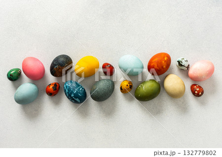 Various Easter eggs in vibrant colors and patterns are neatly arranged, showcasing the joy and creativity associated with spring celebrations and family gatherings 132779802