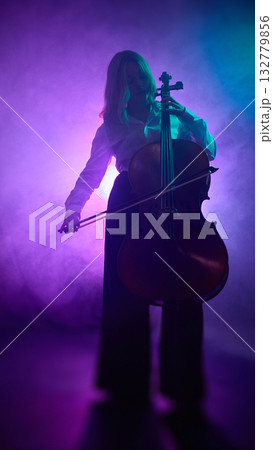 Female cellist standing and playing under purple studio lighting 132779856