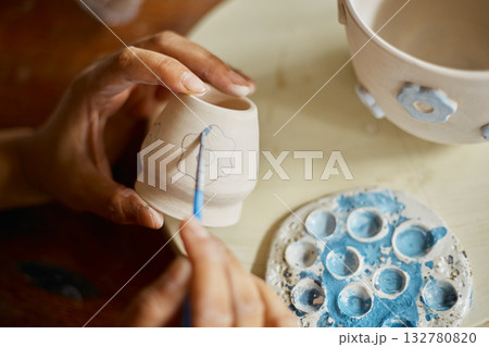 Close up hand of woman painting her pottery ceramic Close up hand of woman painting her pottery ceramic 132780820