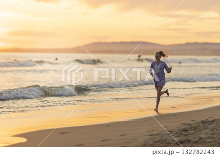 Young woman running enjoying freedom on beach sunset 132782243