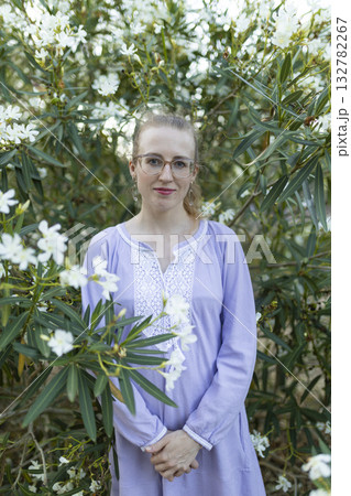 Young woman smiling in lavender dress among white flowers 132782267