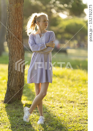 Young woman relaxing in park enjoying golden hour sunset 132782275