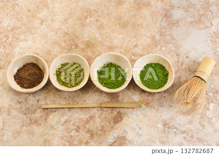 Matcha Tea Ceremony Set, Overhead view of matcha bowls, bamboo whisk, and scoop on a textured surface. Matcha Tea Ceremony Set, Overhead view of matcha bowls, bamboo whisk, and scoop on a textured surface. 132782687