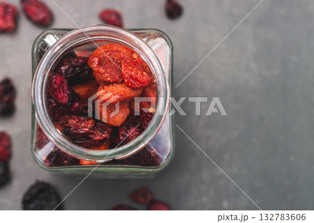 Dried cranberries in a glass jar on dark background Dried cranberries in a glass jar on dark background 132783606