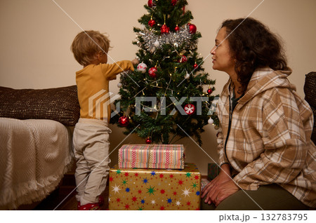 Mother And Child Decorating Christmas Tree At Home With Gifts And Cozy Holiday Atmosphere Mother And Child Decorating Christmas Tree At Home With Gifts And Cozy Holiday Atmosphere 132783795