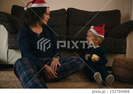 Mother And Child In Santa Hats Share A Cozy Christmas Moment At Home Mother And Child In Santa Hats Share A Cozy Christmas Moment At Home 132784866