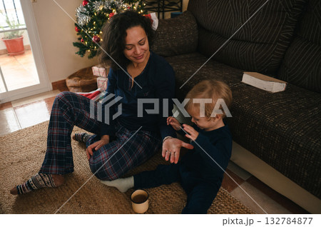 Warm Family Moment: Mother And Child Play On Living Room Floor By Christmas Tree Warm Family Moment: Mother And Child Play On Living Room Floor By Christmas Tree 132784877