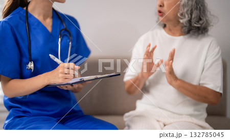 Asian nurse providing nursing care adult patient home consultation medical health service elderly woman explaining condition healthcare support 132785045