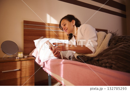 Relaxed Woman In Bed Measuring Tailor Tape After Spa Day In Cozy Bedroom 132785293