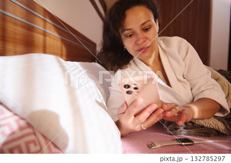 Relaxed Woman In White Robe Using Smartphone In Bed, Cozy Morning Home Scene Relaxed Woman In White Robe Using Smartphone In Bed, Cozy Morning Home Scene 132785297