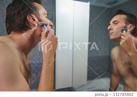 Man Shaving With Razor In Bathroom Mirror - Grooming Routine, Double View, Morning Hygiene 132785802