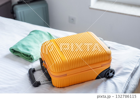 Travel suitcase on hotel bed preparing for journey 132786115