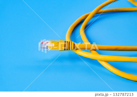 Yellow RJ45 Ethernet cable on color background. 132787213