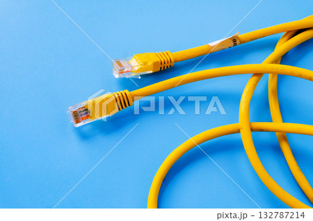 Yellow RJ45 Ethernet cable on color background. 132787214
