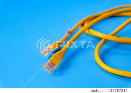 Yellow RJ45 Ethernet cable on color background. 132787215