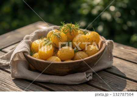 Sunlit rustic potatoes glisten with golden butter and dill in serene Scandinavian summer setting 132787504