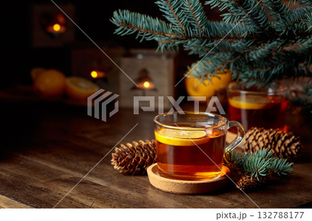Tea with lemon and small Christmas lanterns on a wooden table. 132788177