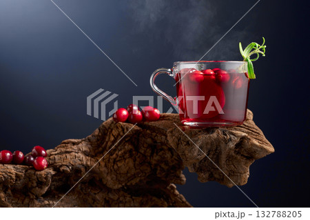 Hot drink with cranberries, lime, and rosemary on a old wooden snag. Hot drink with cranberries, lime, and rosemary on a old wooden snag. 132788205