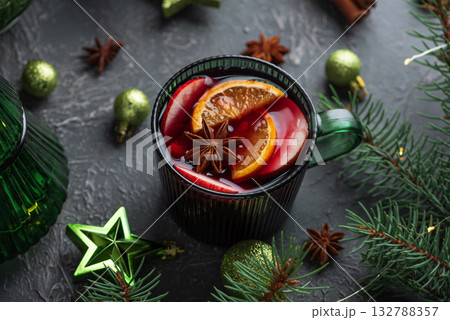 Holiday Mulled Wine with Orange and Apple in Green Mug Surrounded by Christmas Decor Holiday Mulled Wine with Orange and Apple in Green Mug Surrounded by Christmas Decor 132788357