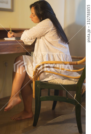 Young woman writing thoughts on notebook at desk. Romantic portrait Young woman writing thoughts on notebook at desk. Romantic portrait 132788855