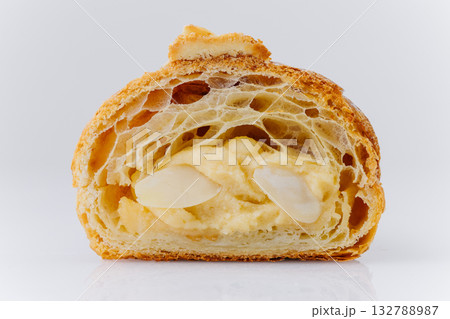 Almond croissant cut in half with creamy filling and powdered sugar on white background Almond croissant cut in half with creamy filling and powdered sugar on white background 132788987