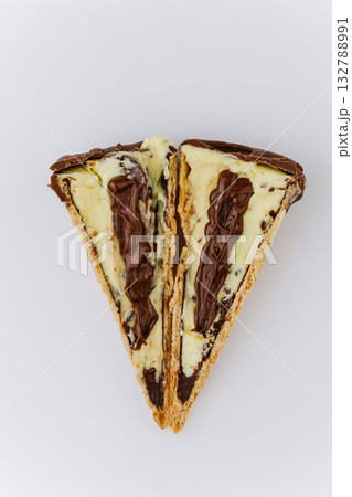 Sliced chocolate and vanilla ice cream cone with creamy filling on white background Sliced chocolate and vanilla ice cream cone with creamy filling on white background 132788991