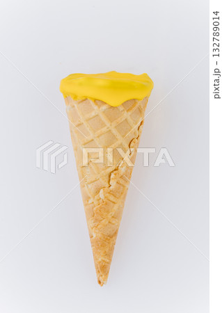 Yellow ice cream cone isolated on white background, bright minimal summer dessert concept Yellow ice cream cone isolated on white background, bright minimal summer dessert concept 132789014