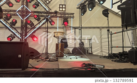 Music festival stage setup with drums and lighting equipment 132789591