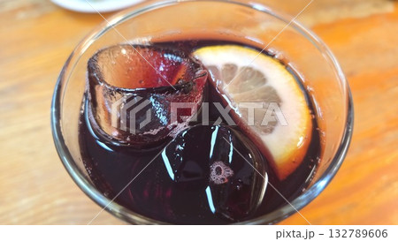 Refreshing beverage with lemon and ice cubes on a sunny day. Spanish drink tinto de verano. Close-up 132789606