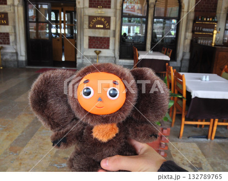 Cheburashka toy held in front of a historic restaurant in Istanbul. Nostalgia, humor, and the joyful spirit of travel and discovery. 132789765
