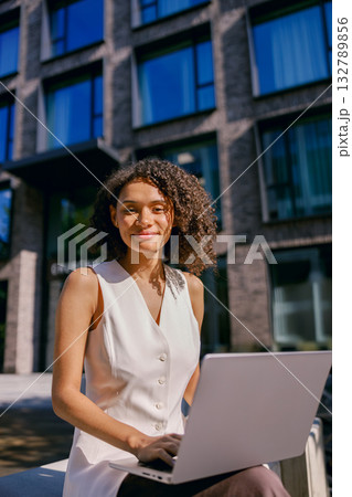 female working outdoors, woman typing outside office, professional woman engaged in remote work female working outdoors, woman typing outside office, professional woman engaged in remote work 132789856