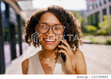 outdoor shot of confident woman on call, vibrant city scene captured with friendly professional 132789891