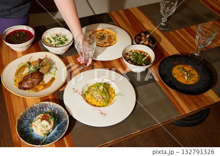 An Artistic Food Display Artfully Arranged on a Beautiful Wooden Table with Elegant Glassware 132791326