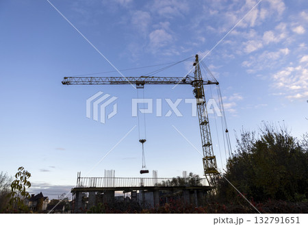 Construction cranes work on creation site against blue sky background. 132791651