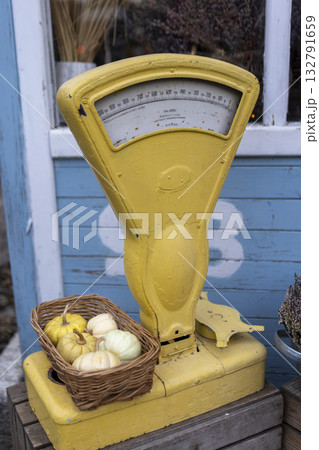 Yellow grocery scale with a basket of decorative pumpkins Yellow grocery scale with a basket of decorative pumpkins 132791659
