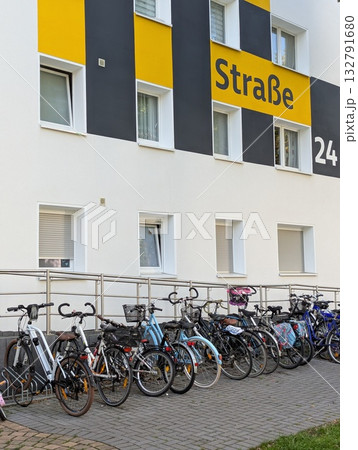 Many bicycles parked near a residential building Many bicycles parked near a residential building 132791680