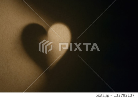 A heart-shaped shadow on the wall is a symbol of love. Space for text. A heart-shaped shadow on the wall is a symbol of love. Space for text. 132792137