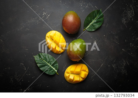 Ripe tropical sliced whole mangoes leaves dark background healthy exotic fruit Ripe tropical sliced whole mangoes leaves dark background healthy exotic fruit 132793034