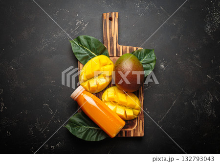 Fresh mango exotic tropical fruit juice smoothie bowl cutting board dark background orange Fresh mango exotic tropical fruit juice smoothie bowl cutting board dark background orange 132793043