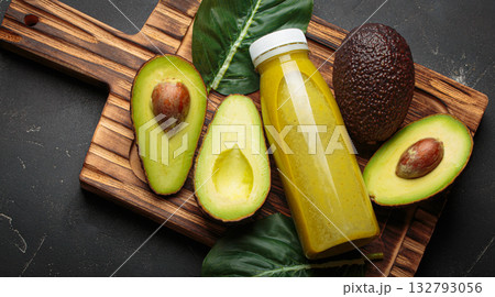 Avocado smoothie fresh fruit halves dark background cutting board healthy drink diet nutrition Avocado smoothie fresh fruit halves dark background cutting board healthy drink diet nutrition 132793056