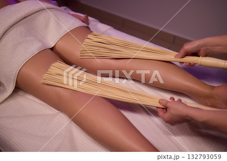 Experience relaxation and muscle relief with a spa treatment using bamboo sticks for rejuvenation Experience relaxation and muscle relief with a spa treatment using bamboo sticks for rejuvenation 132793059