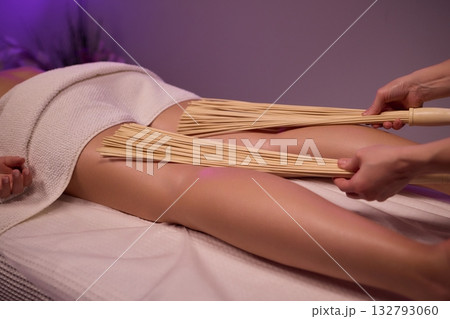 Experience relaxation and muscle relief with a spa treatment using bamboo sticks for rejuvenation 132793060